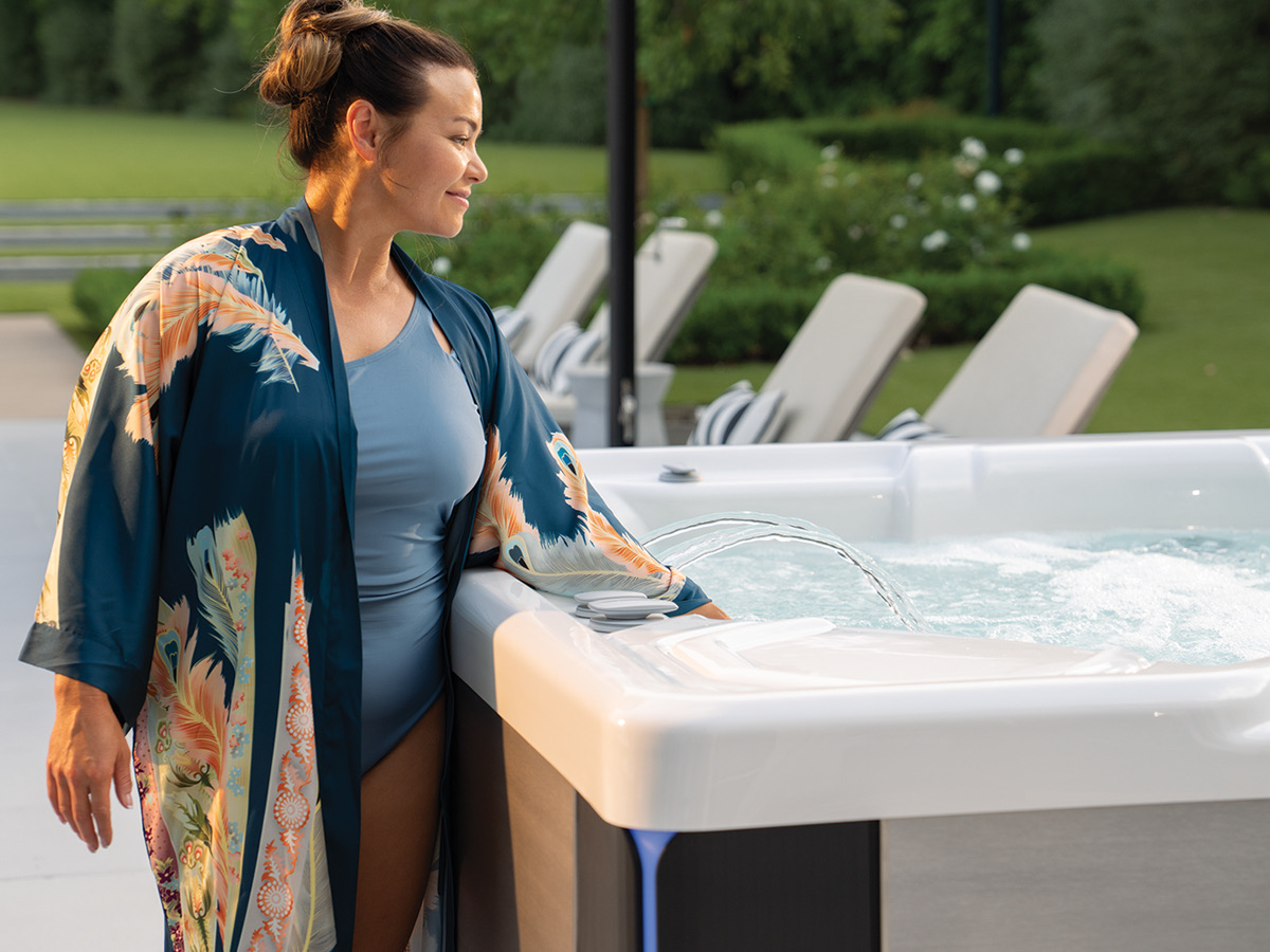 Woman in a robe relaxing beside a Hot Spring Spa hot tub